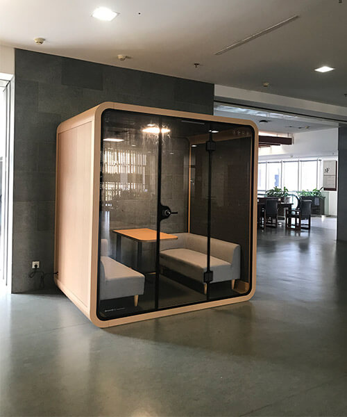 Soundbox's large khaki office privacy pod is placed in office