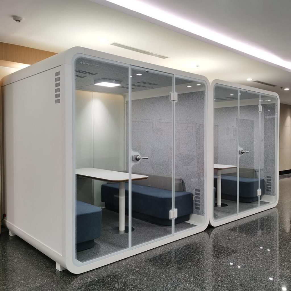 Two x-large white office privacy pods are placed in bank lobby